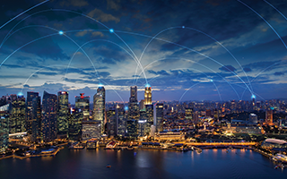 A cityscape by a water body, lit up at dusk