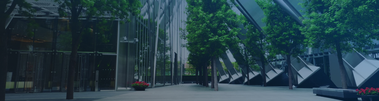Glass office buildings lined with trees, overlaid with a blue gradient