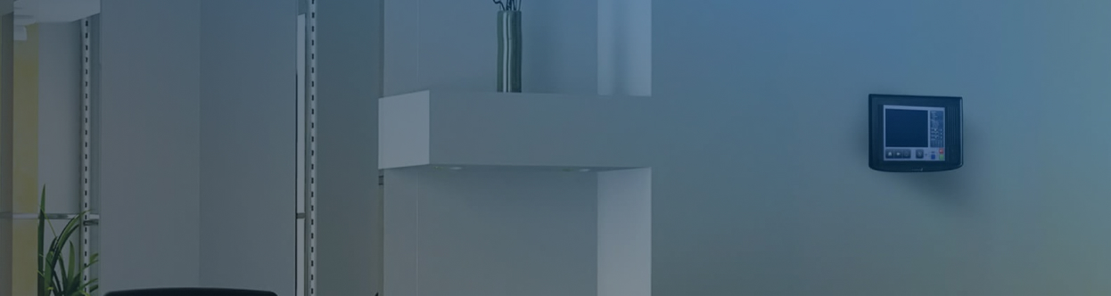 A PROFILE fire detection unit mounted on an office wall, overlaid with a blue gradient